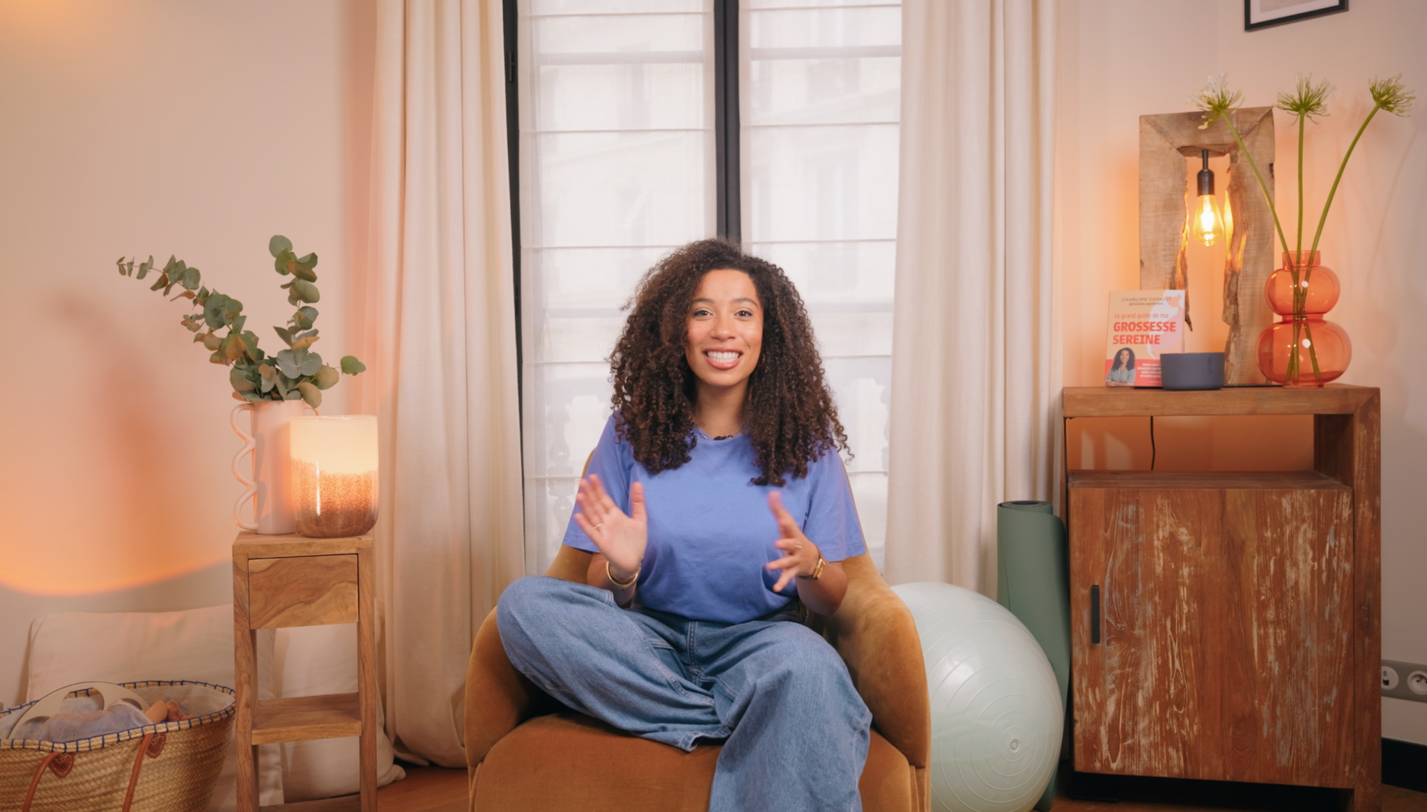 Charline Gayault assise dans un décor doux pour présenter le guide pratique Mon accouchement serein